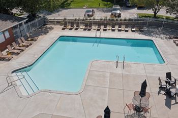 A large outdoor swimming pool surrounded by lounge chairs.